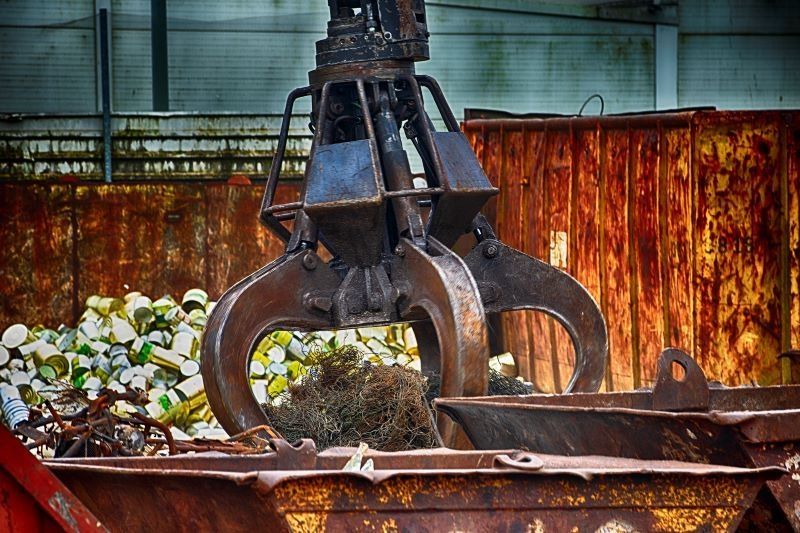 Industriekran über Metallschrott in einer Recyclinganlage.